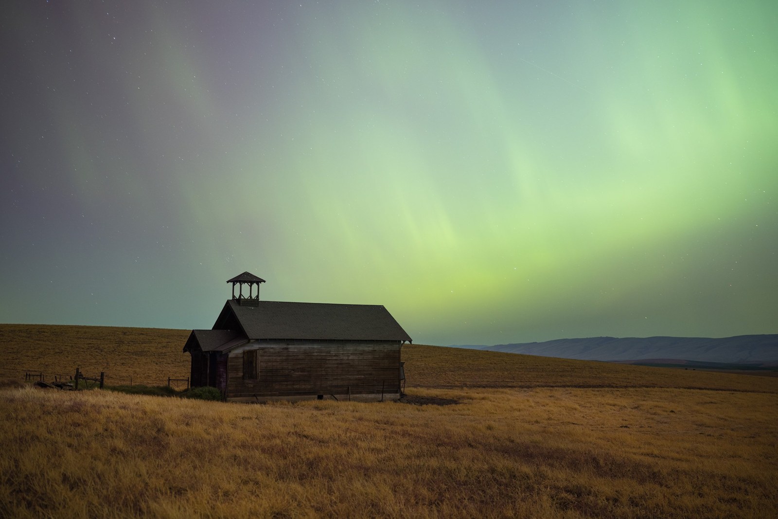 Green aurora over schoolhouse